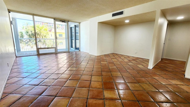 tiled spare room featuring a textured ceiling