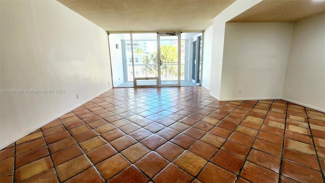 unfurnished room with a textured ceiling and tile patterned floors