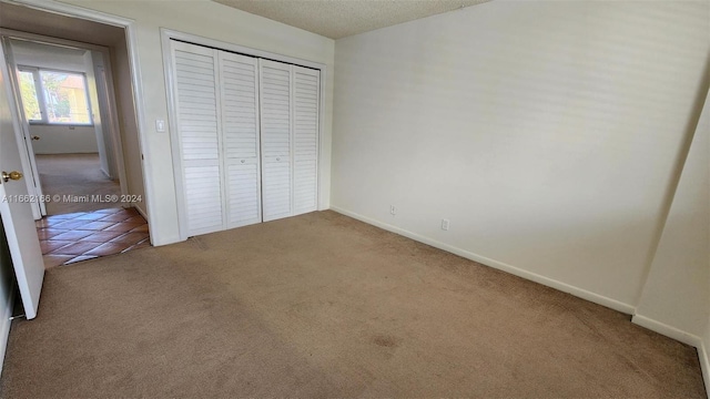 unfurnished bedroom featuring carpet flooring and a closet