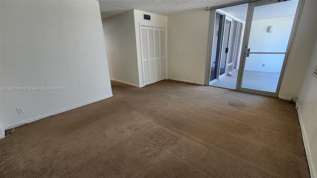 spare room featuring a textured ceiling and carpet