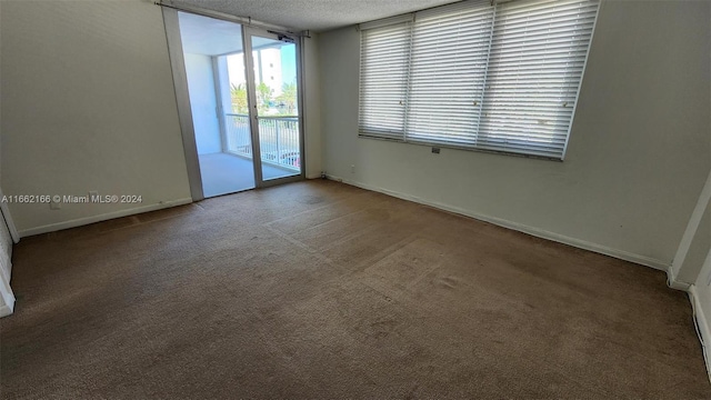 carpeted empty room with a textured ceiling