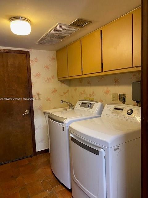 washroom featuring cabinets, dark tile patterned flooring, washer and dryer, and sink