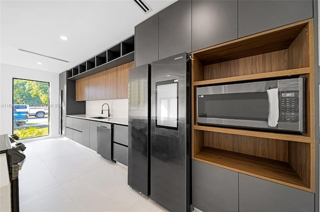 kitchen featuring stainless steel appliances, light tile patterned floors, and sink