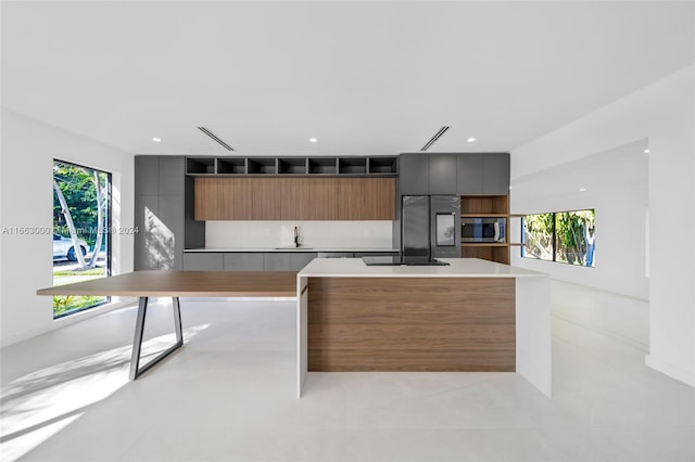 kitchen with appliances with stainless steel finishes, a kitchen island, and sink