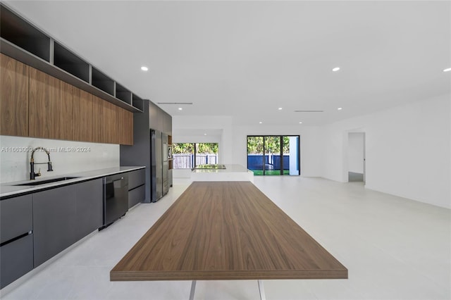 kitchen with appliances with stainless steel finishes, light tile patterned flooring, and sink