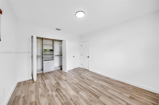 unfurnished bedroom featuring a closet and light hardwood / wood-style floors