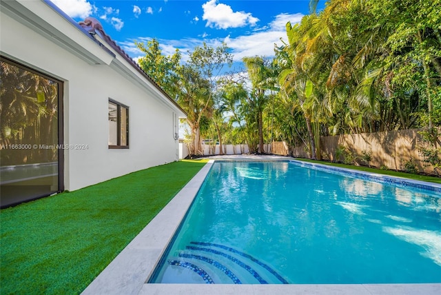 view of swimming pool featuring a yard