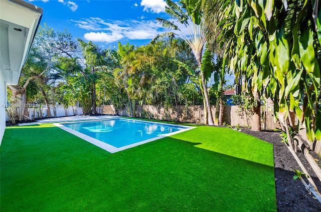 view of swimming pool featuring a yard