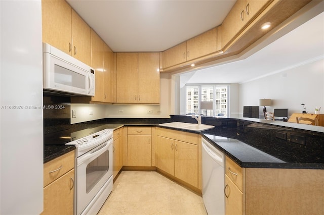 kitchen featuring light brown cabinetry, dark stone countertops, sink, and white appliances