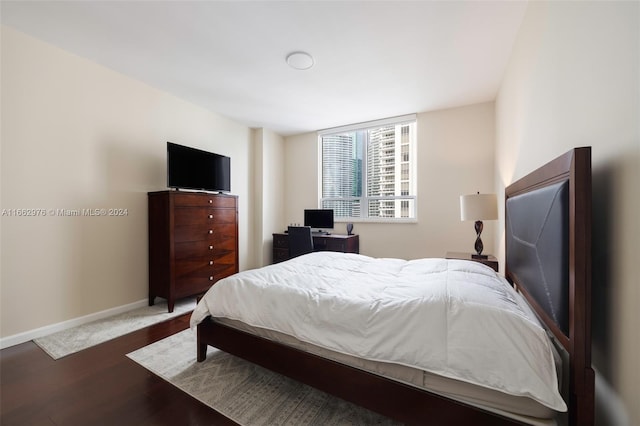 bedroom with dark hardwood / wood-style floors