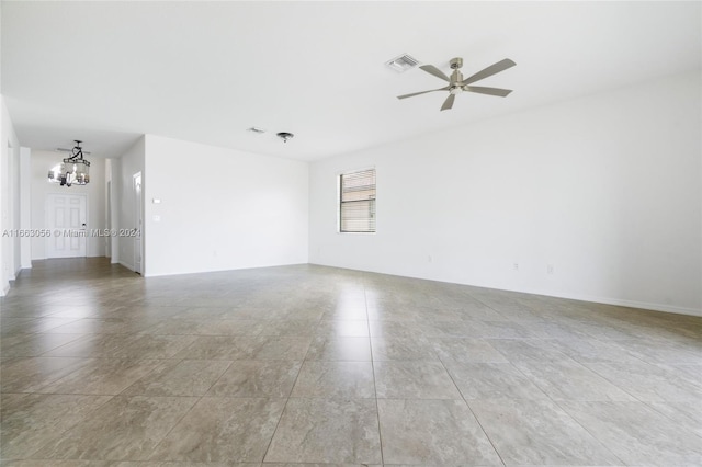 unfurnished room featuring ceiling fan with notable chandelier