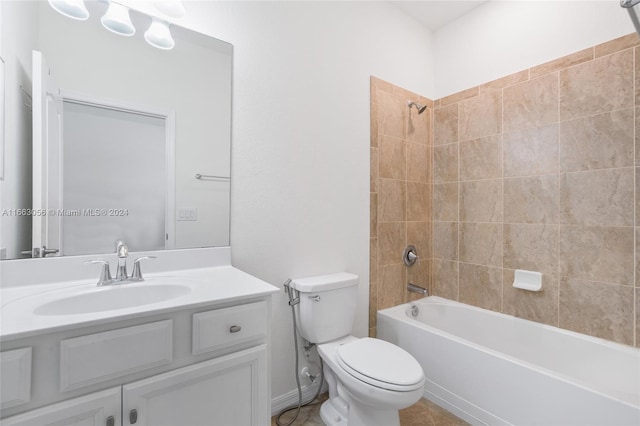 full bathroom featuring tiled shower / bath combo, vanity, and toilet