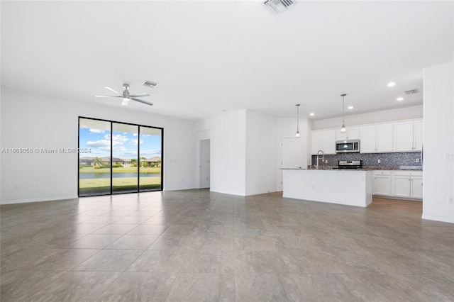 unfurnished living room featuring ceiling fan and sink