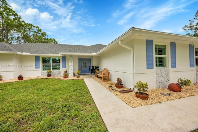 view of exterior entry featuring a yard and covered porch