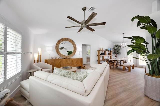 living room featuring light wood-type flooring, lofted ceiling, ceiling fan, and plenty of natural light