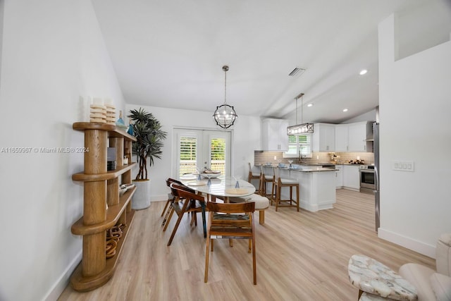 dining area featuring french doors, lofted ceiling, and light hardwood / wood-style floors