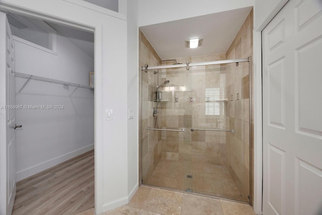 bathroom featuring wood-type flooring and walk in shower