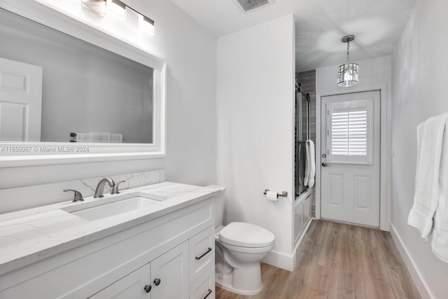 full bathroom featuring wood-type flooring, shower / bathing tub combination, vanity, and toilet