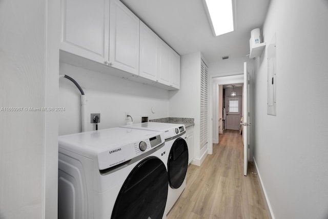 laundry area with separate washer and dryer, light hardwood / wood-style flooring, and cabinets