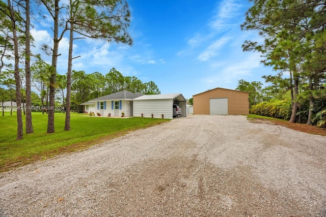 ranch-style home featuring an outbuilding, a garage, and a front yard