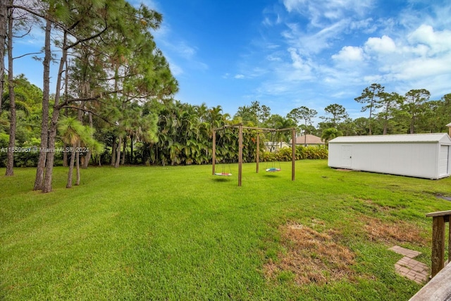 view of yard with a storage shed and a playground