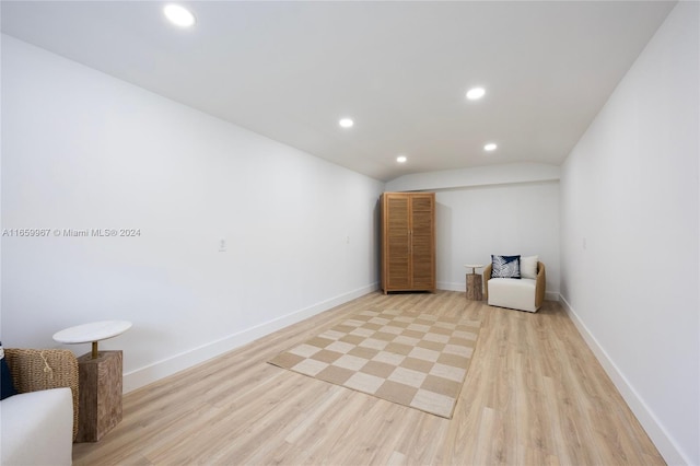 unfurnished room featuring light wood-type flooring and vaulted ceiling