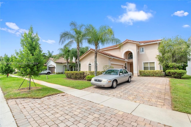 mediterranean / spanish-style home with a front yard and a garage