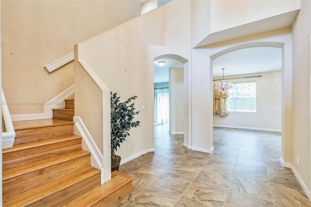 stairs featuring a high ceiling and an inviting chandelier