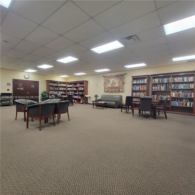 interior space with carpet flooring and a drop ceiling