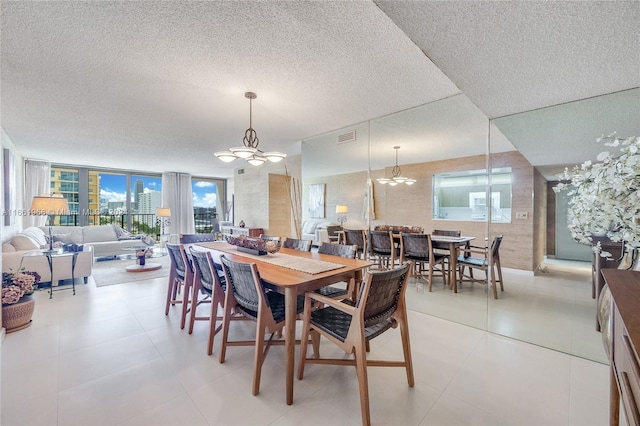 dining room with a textured ceiling, a wall of windows, and an inviting chandelier