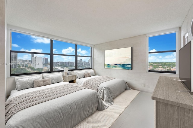 bedroom with a textured ceiling and a wall of windows