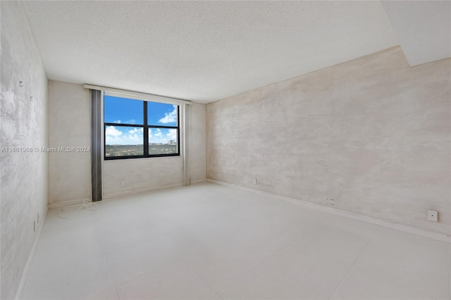 unfurnished room with a textured ceiling