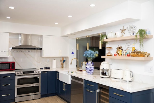 kitchen featuring wine cooler, sink, white cabinets, wall chimney range hood, and stainless steel appliances