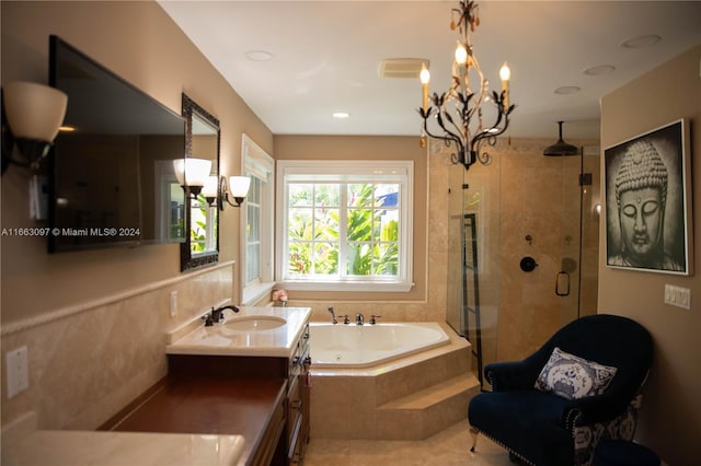 bathroom featuring independent shower and bath, vanity, and a notable chandelier