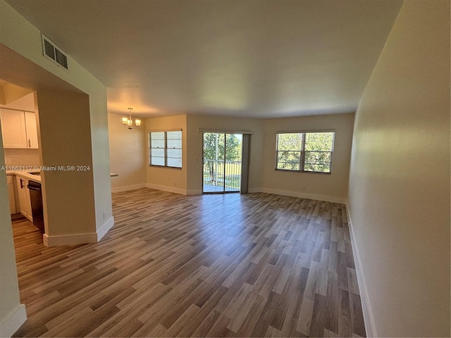 unfurnished living room with hardwood / wood-style floors and a notable chandelier