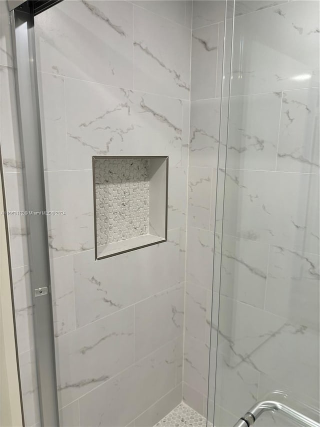 bathroom with a shower with door