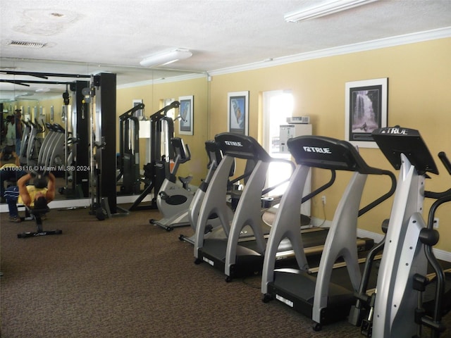 exercise room with a textured ceiling and ornamental molding