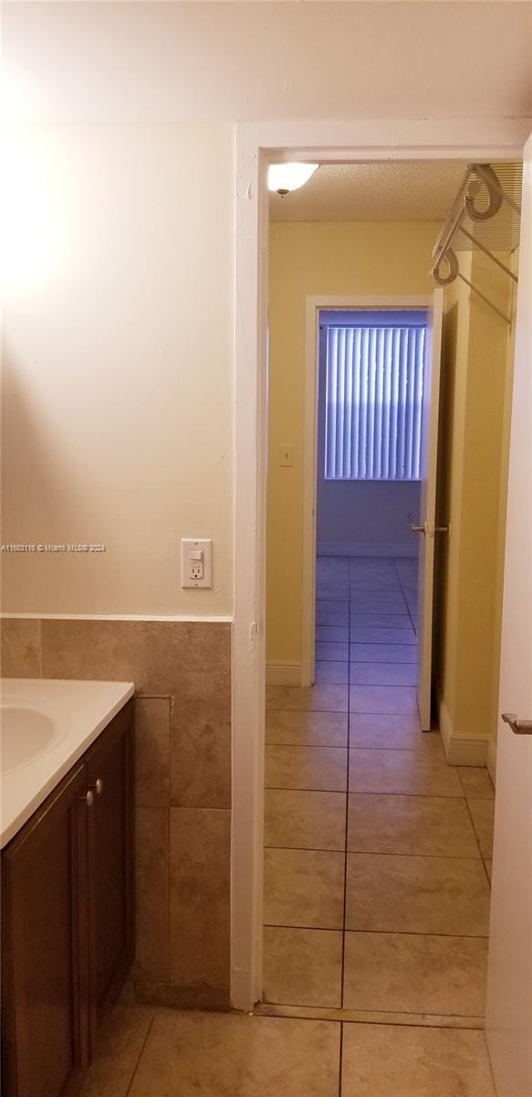 bathroom with vanity, tile walls, and tile patterned floors