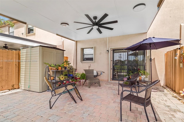 view of patio / terrace with ceiling fan, a storage shed, and central air condition unit