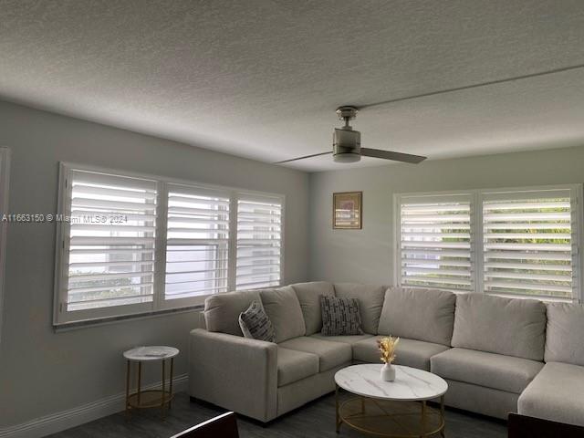 living room with ceiling fan and a textured ceiling