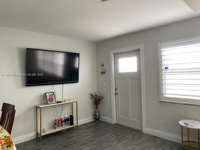 entrance foyer featuring a textured ceiling and dark wood-type flooring