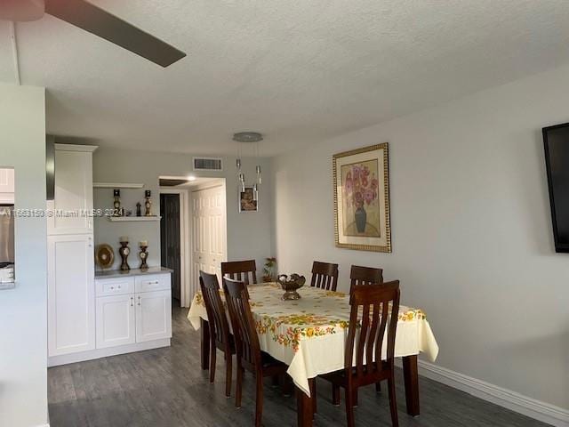 dining room featuring a textured ceiling and dark wood-type flooring