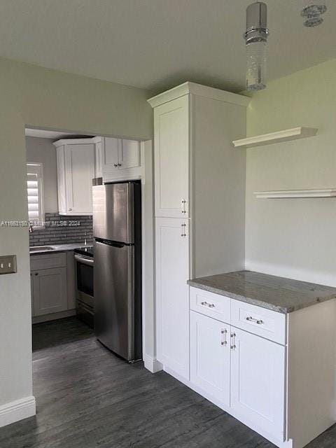 kitchen featuring decorative backsplash, stainless steel appliances, white cabinets, and dark wood-type flooring