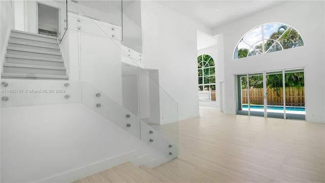 stairway featuring a towering ceiling and hardwood / wood-style floors