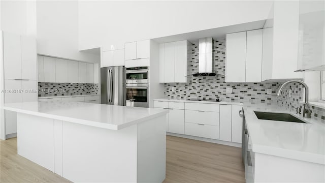 kitchen featuring white cabinets, appliances with stainless steel finishes, sink, and a kitchen island