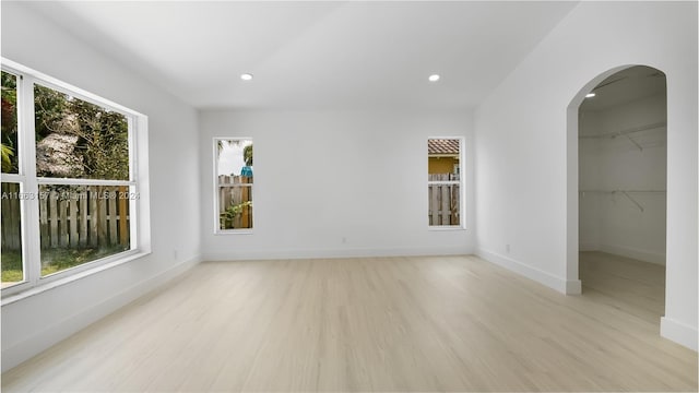 spare room featuring light hardwood / wood-style floors and a healthy amount of sunlight