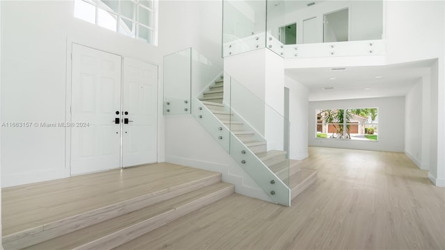 staircase featuring hardwood / wood-style floors and a high ceiling