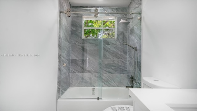 full bathroom with tiled shower / bath, vanity, and toilet