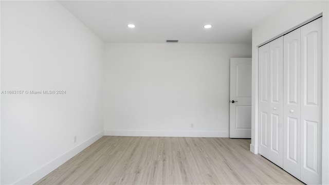 unfurnished bedroom featuring light hardwood / wood-style flooring and a closet