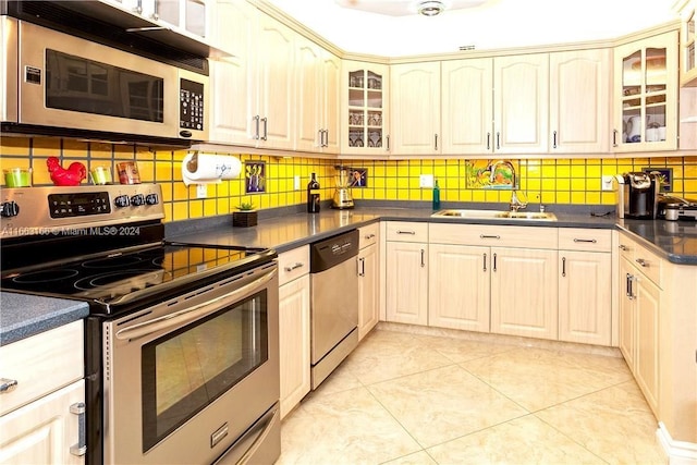 kitchen featuring decorative backsplash, sink, light tile patterned floors, and stainless steel appliances